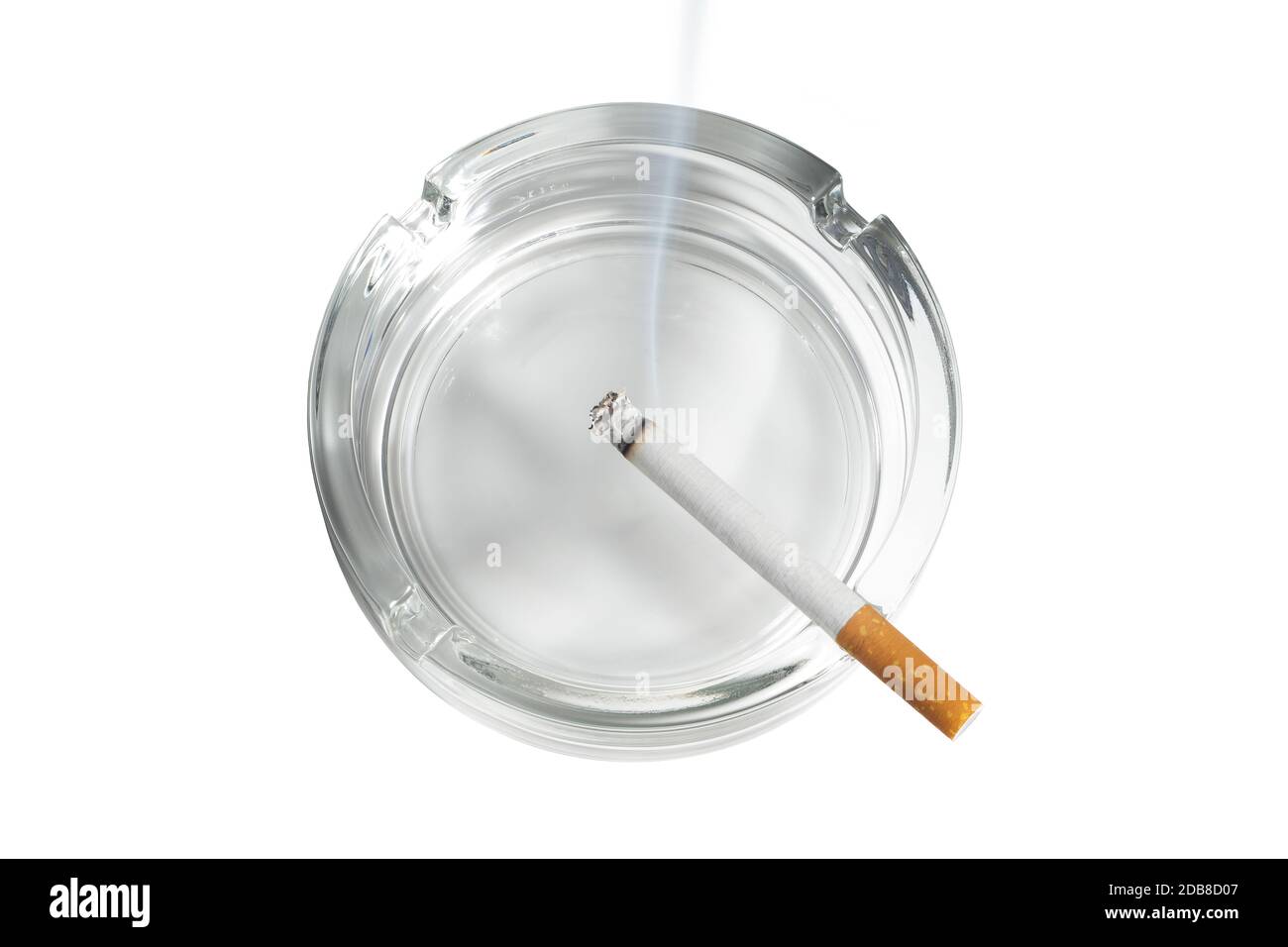 The top view of a cigarette lit in glass ashtray on white Stock Photo