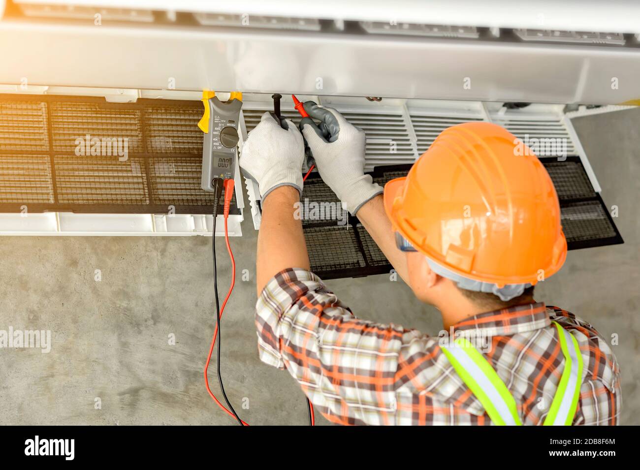 Electrician installing an air conditioning unit on a wall, Thailand Stock Photo