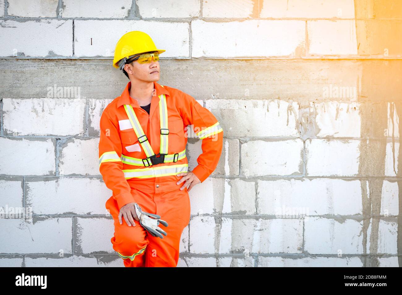 Portrait of a construction worker in reflective clothing leaning against a wall, Thailand Stock Photo
