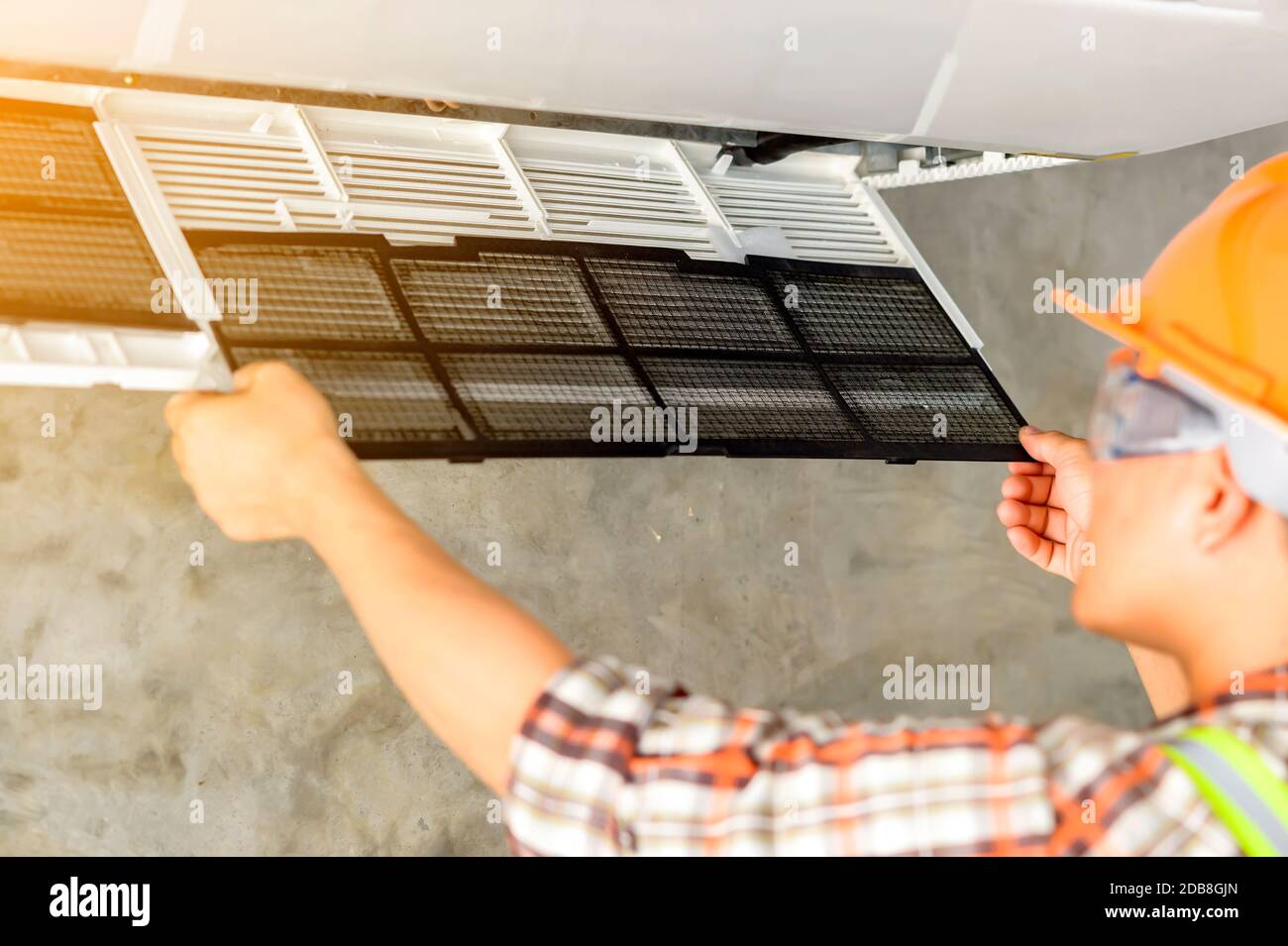 Technician installing an air conditioning unit on a wall, Thailand Stock Photo