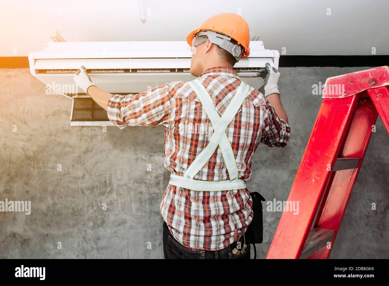 Technician installing an air conditioning unit on a wall, Thailand Stock Photo