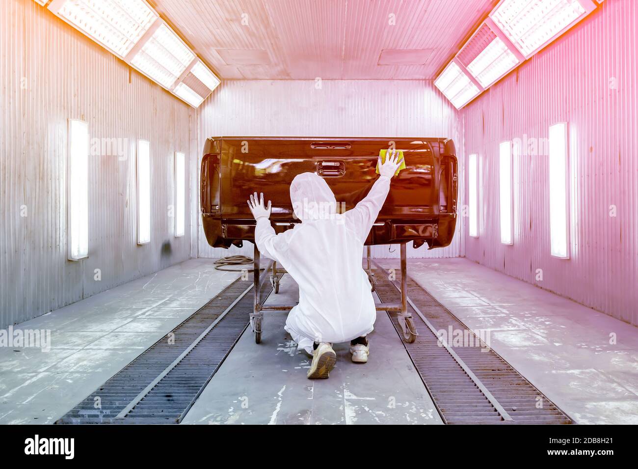 Rear view of a man polishing a car's paintwork, Thailand Stock Photo