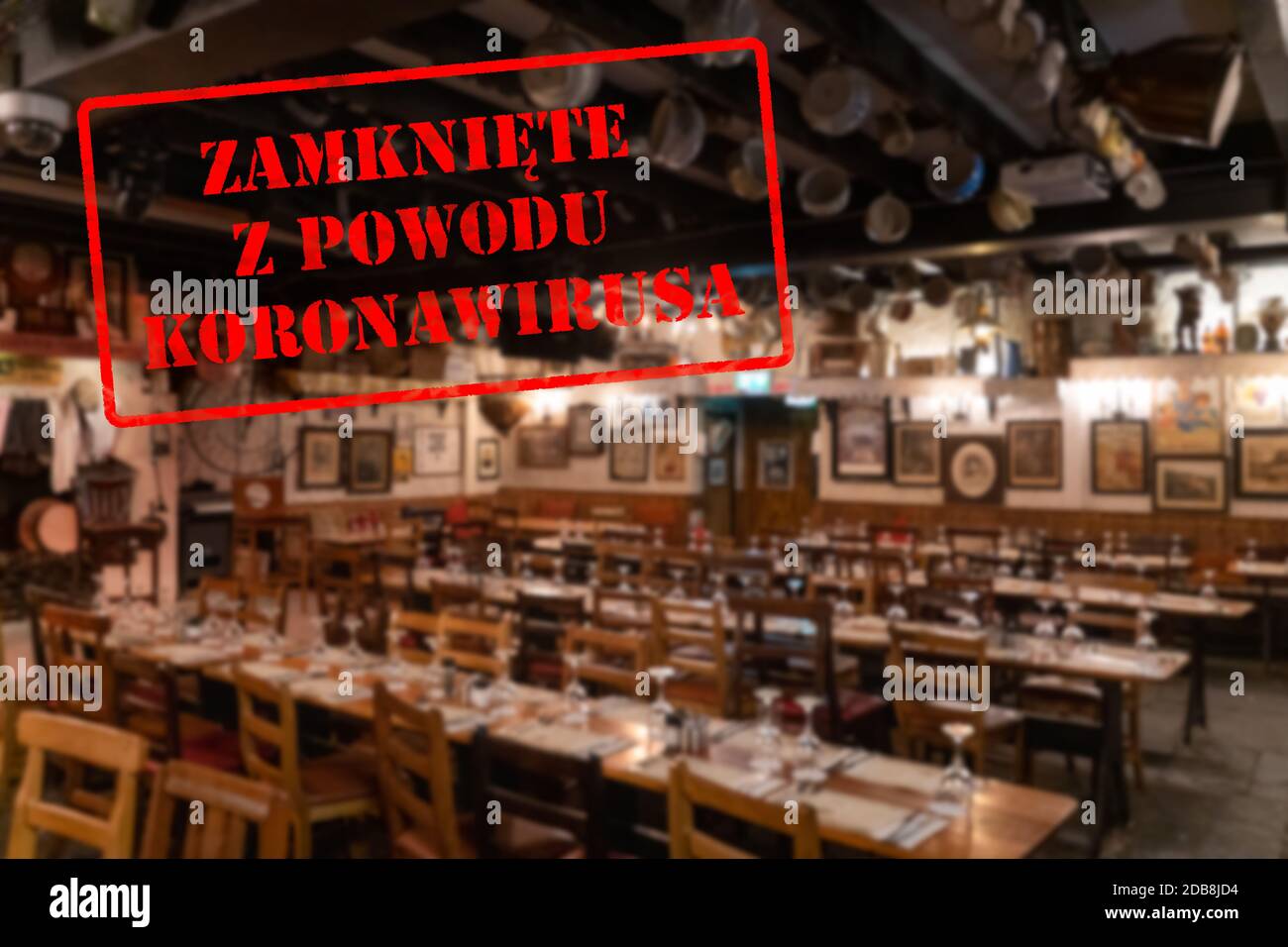 Defocused, blurred view of interior of traditional bar or restaurant, empty and closed due to covid 19 with Polish notice Closed due to Coronavirus Stock Photo