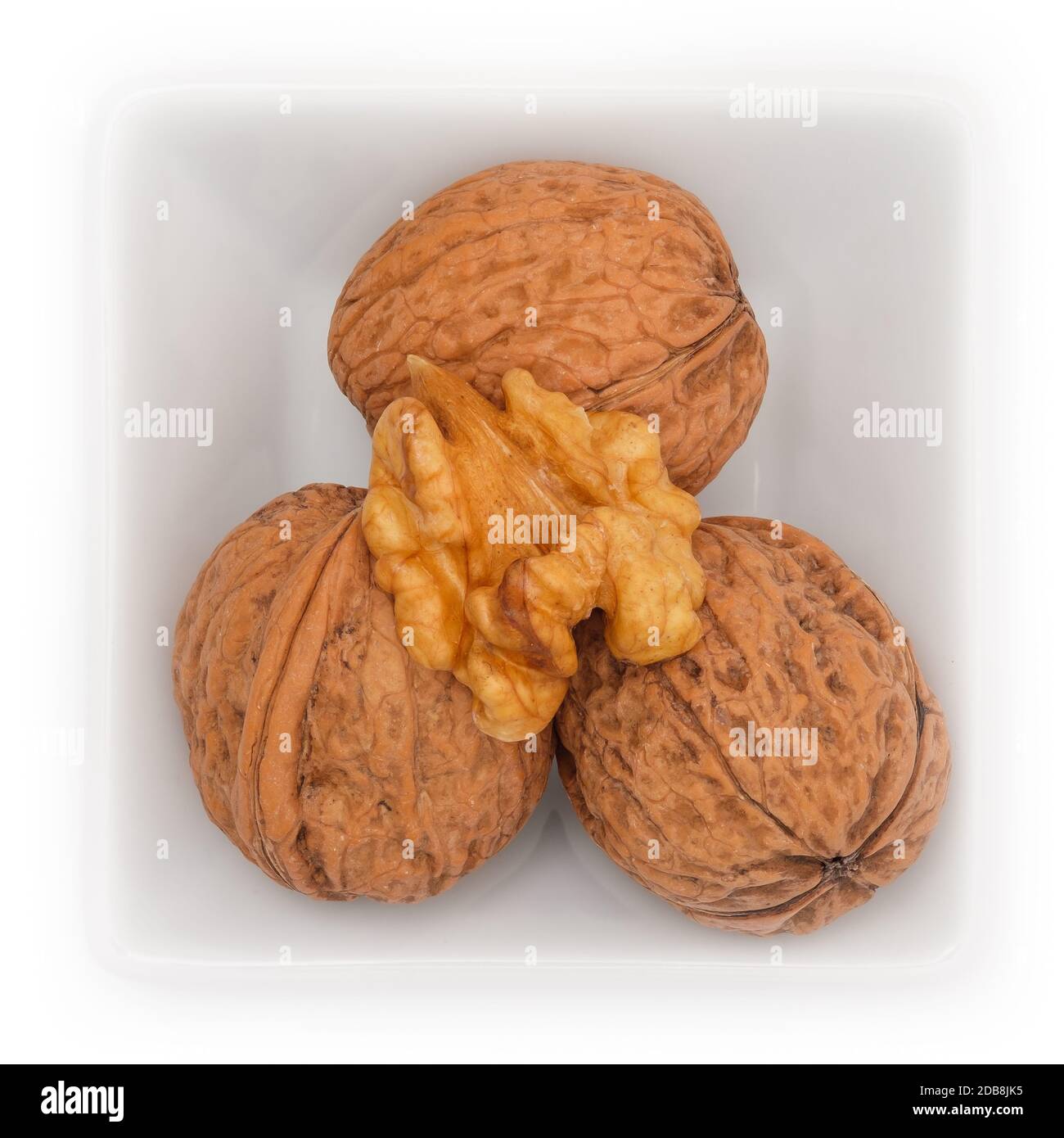 Walnut with nutshell in a bowl in top view Stock Photo