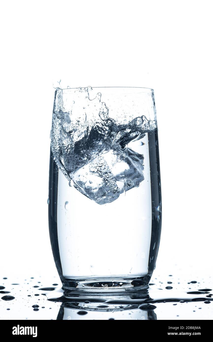 Ice cube falling in a glass of water splash water drops Stock Photo - Alamy