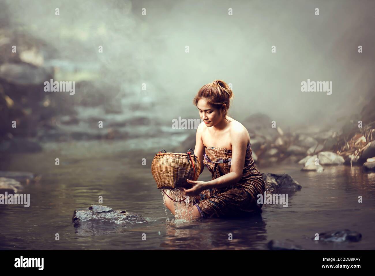 Woman sitting in a river bathing, Thailand Stock Photo