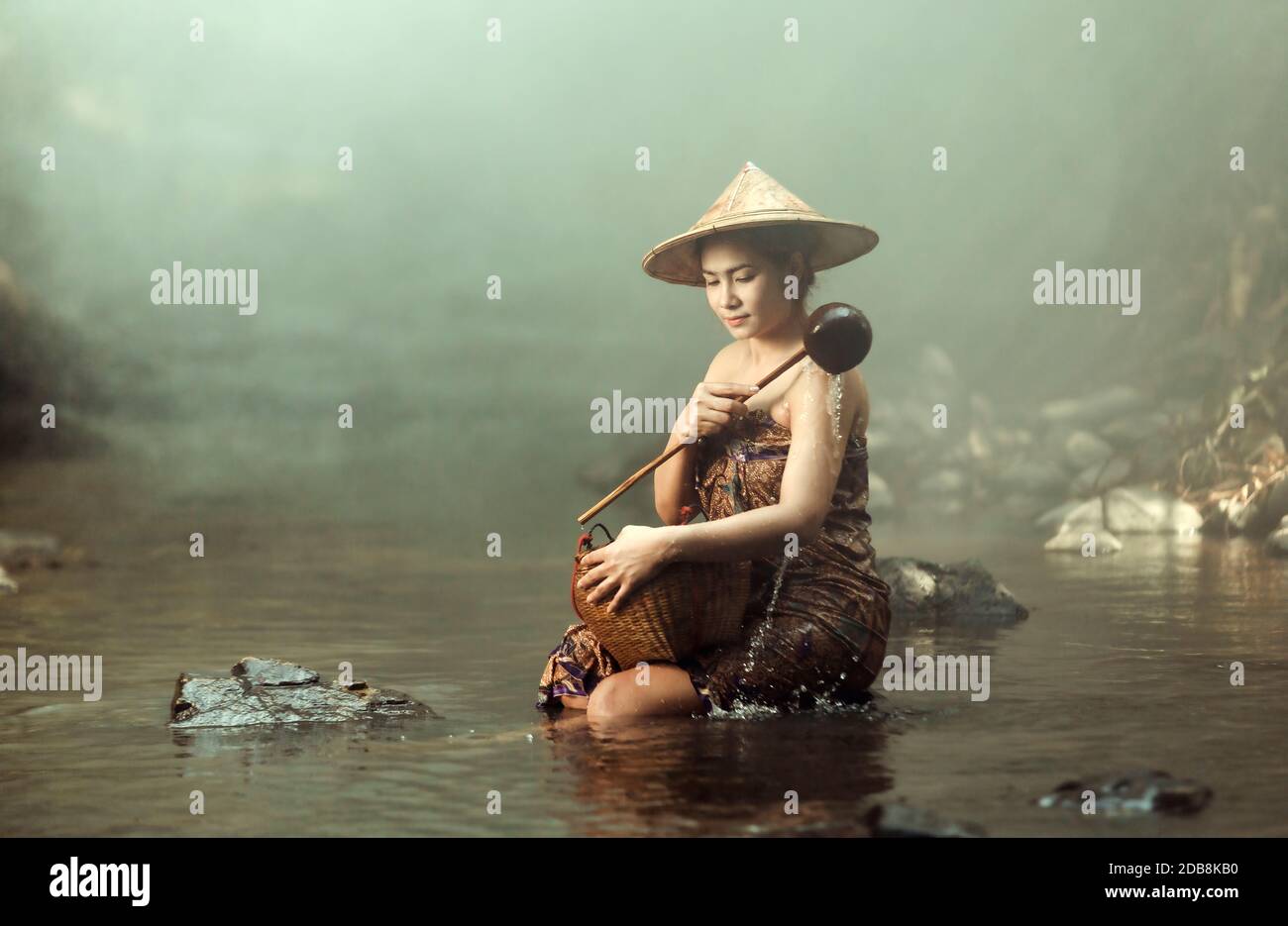 Woman sitting in a river bathing, Thailand Stock Photo