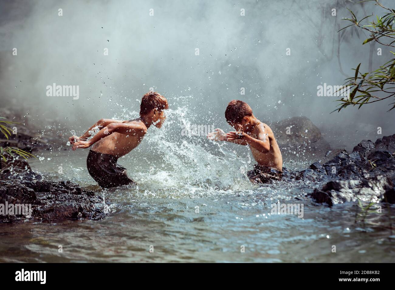 Two boys washing in a river, Thailand Stock Photo