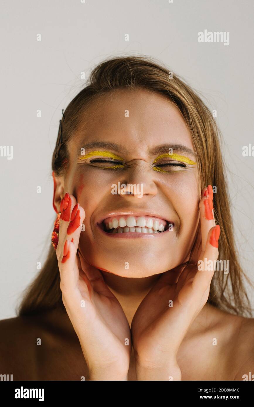 Portrait of a smiling woman wearing unusual make-up Stock Photo