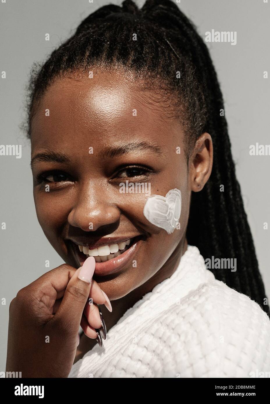 Portrait of a Smiling woman with cream on her face in a heart shape Stock Photo