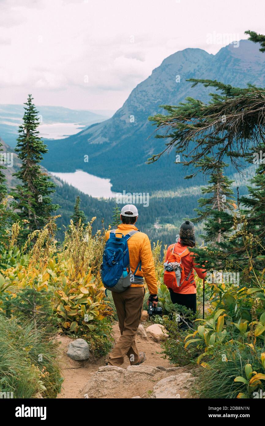 Couple's hiking beautiful trail in Glacier National Park, Montana Stock Photo