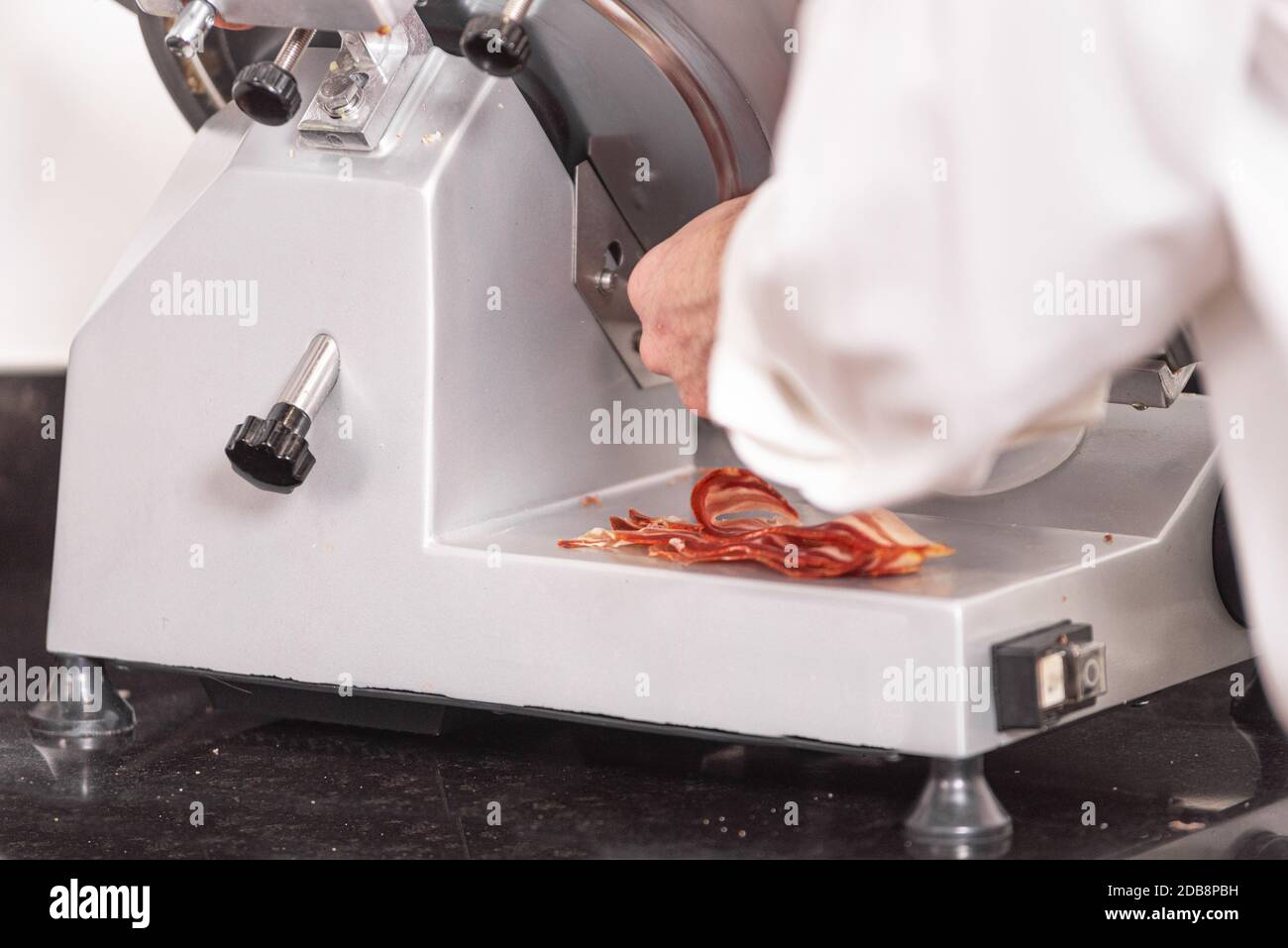 https://c8.alamy.com/comp/2DB8PBH/chef-using-ham-slicer-machine-slicing-bacon-2DB8PBH.jpg