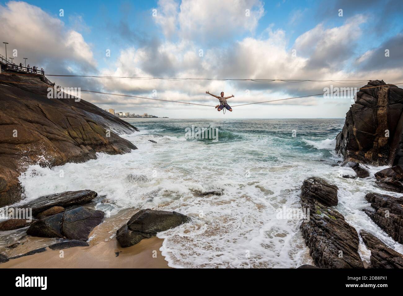 Man slacklining on seashore, Leblon Beach, Rio de Janeiro, Brazil Stock Photo