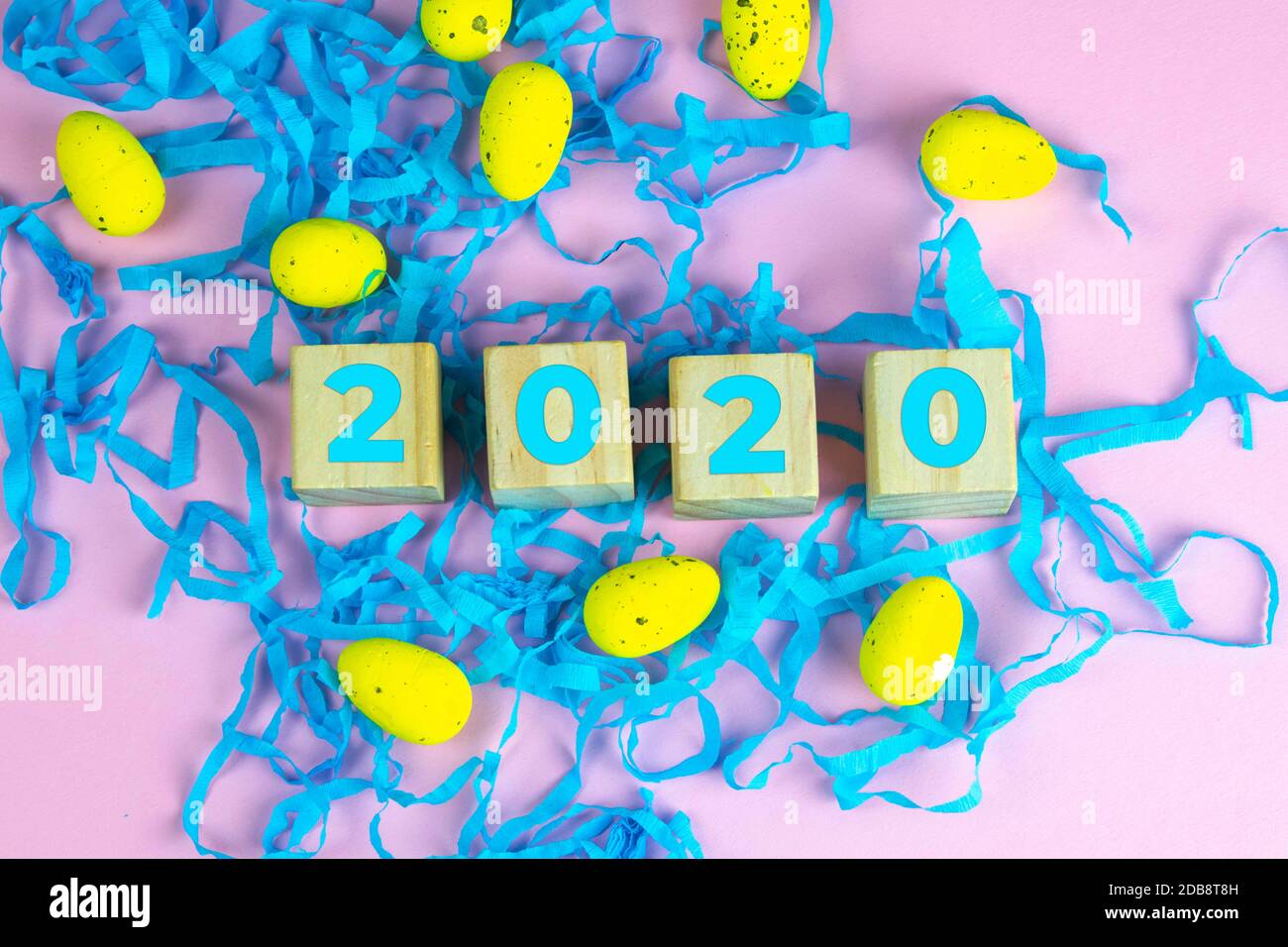 Word Easter on wooden cubes and surrounded with multiple egg decorations as a festive Easter background composition. Stock Photo