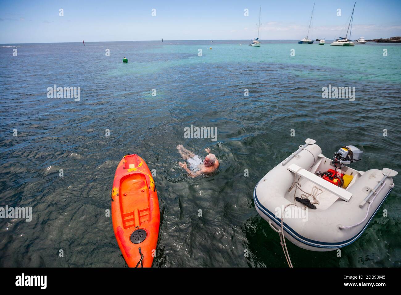 Active man swims off the back of his boat, Rottnest Island, Australia ...