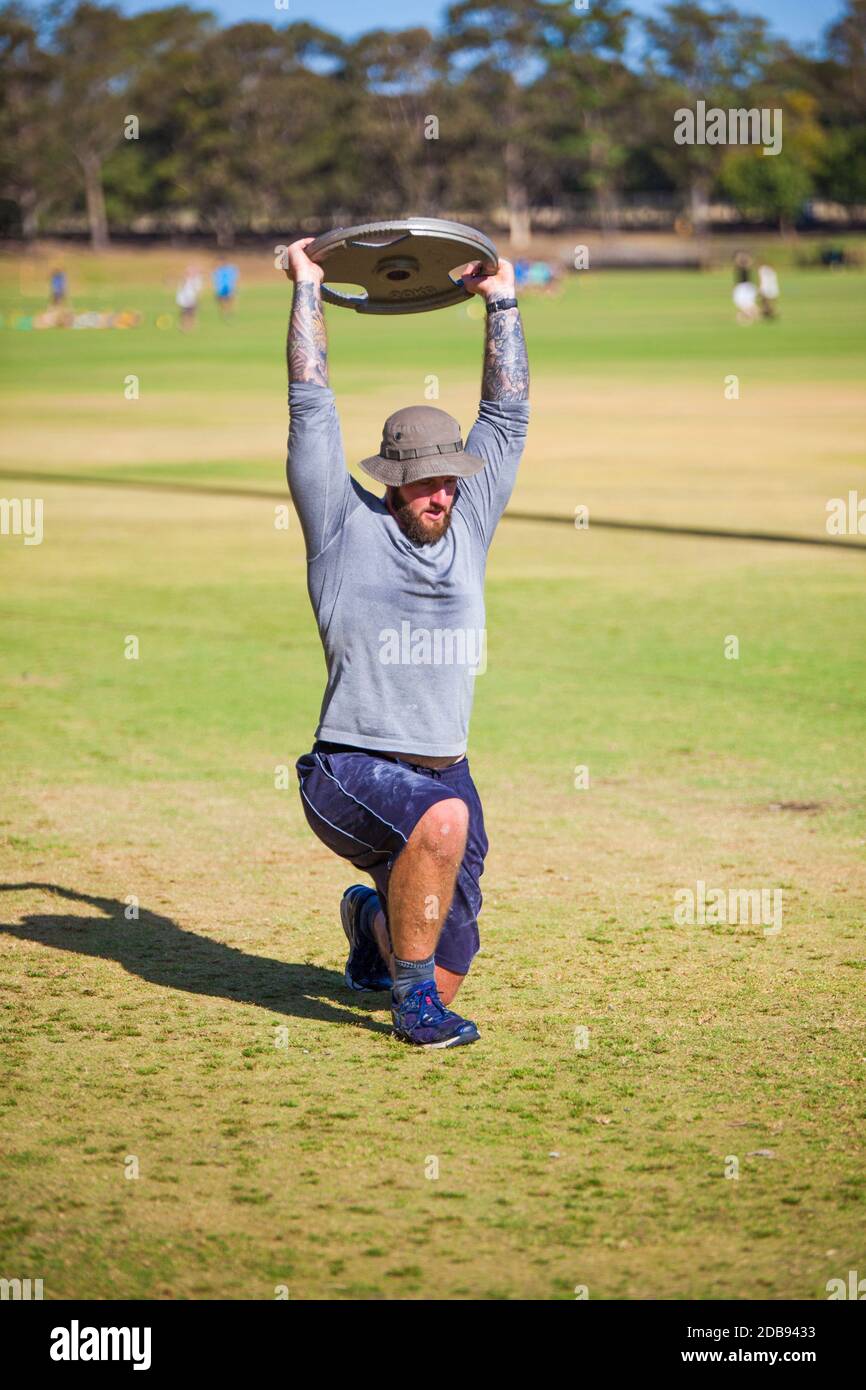 Man doing lunges with weights Stock Photo