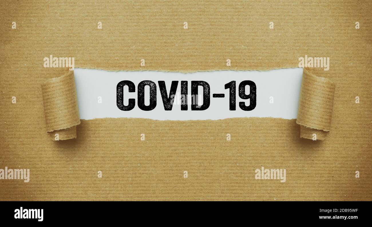 Torn paper revealing the word COVID-19 Stock Photo - Alamy