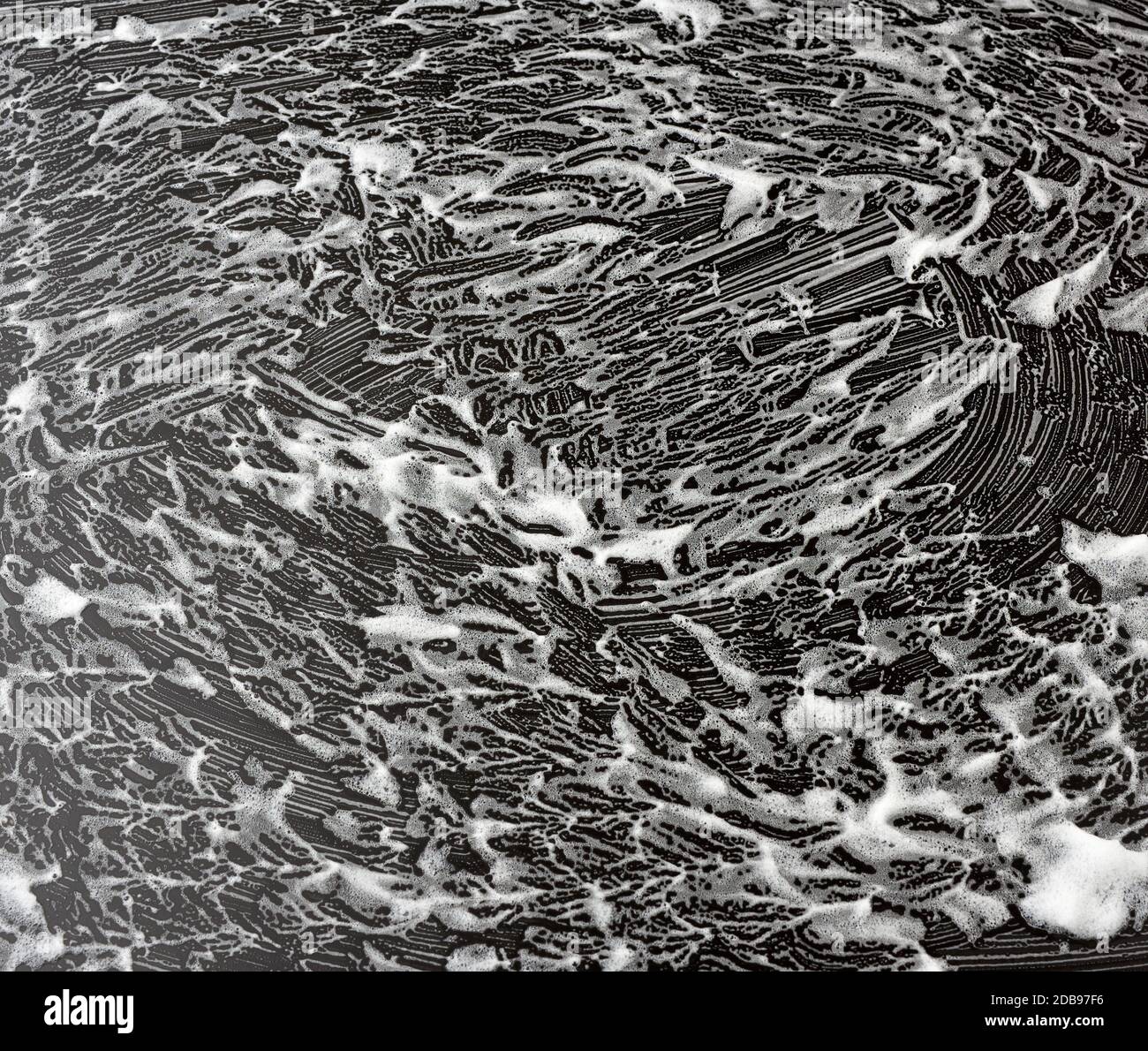 white soap foam on a black background, top view, concept of cleanliness ...
