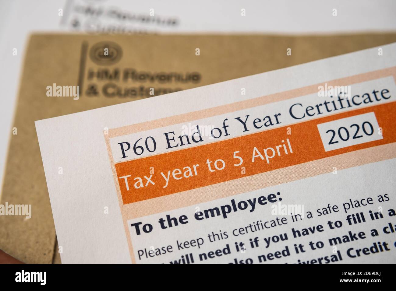 Stafford / United Kingdom - November 16 2020: HM Revenue & Customs (HMRC) P60 End of year certificate letter seen with blurred envelopes on the backgr Stock Photo