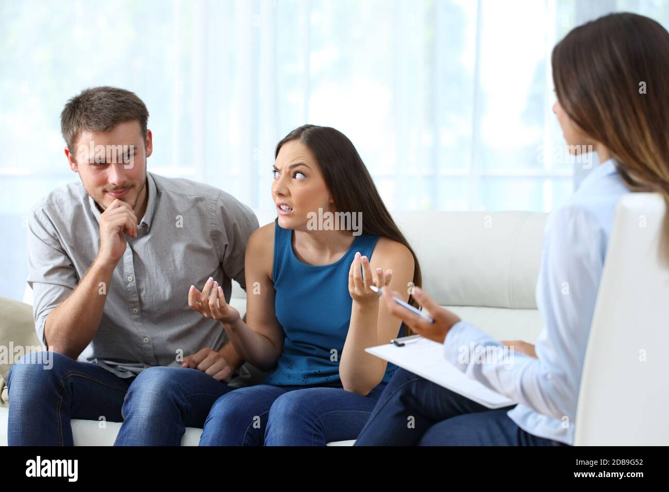 Husband flirting with therapist in couple therapy and getting caught by upset wife Stock Photo