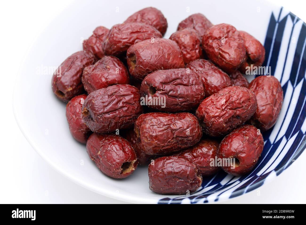 dried jujube fruits in a bowl, chinese herbal medicine on white