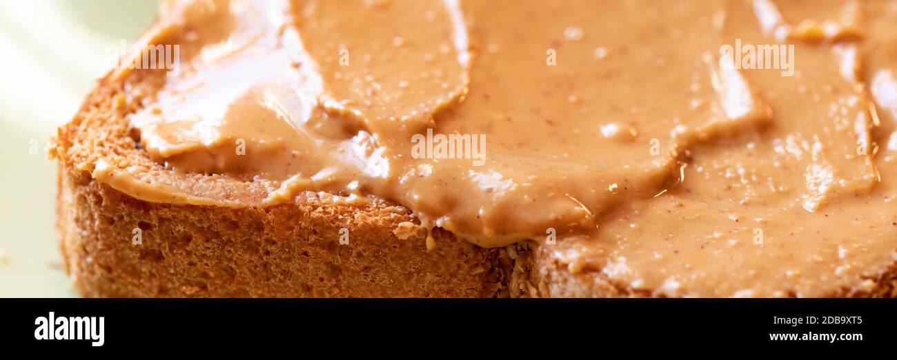 Creamy peanut butter spread on healthy whole wheat toast bread Stock Photo