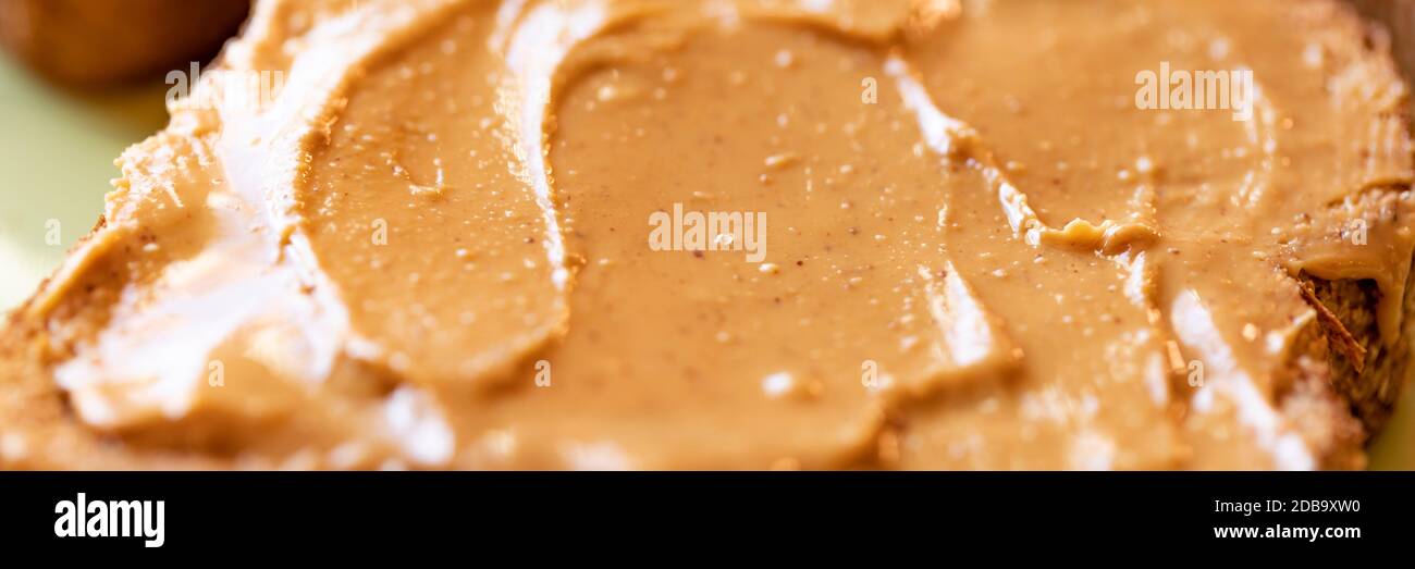 Creamy peanut butter spread on healthy whole wheat toast bread Stock Photo