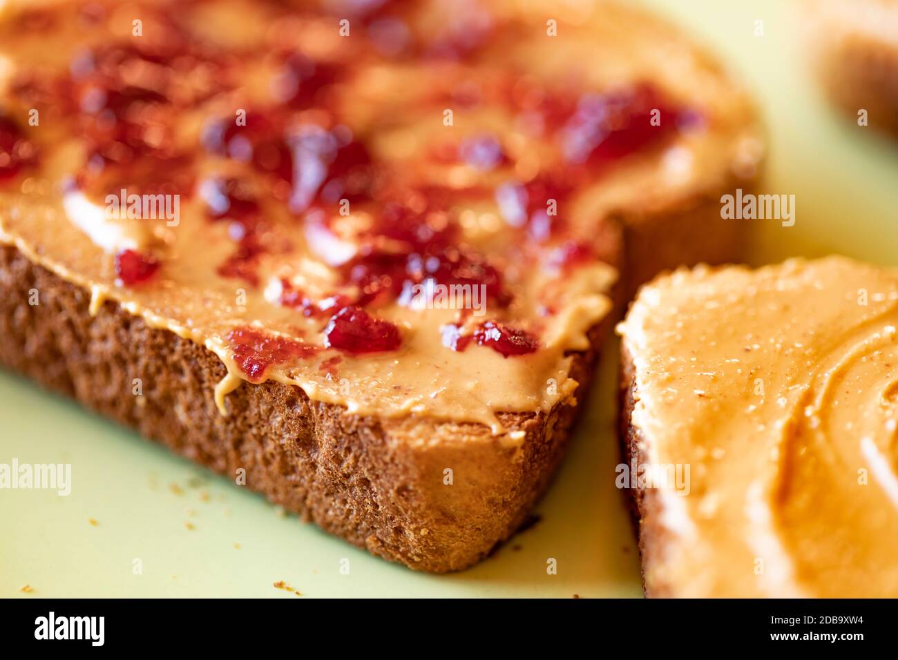 Creamy peanut butter spread with fruit jam on healthy whole wheat toast