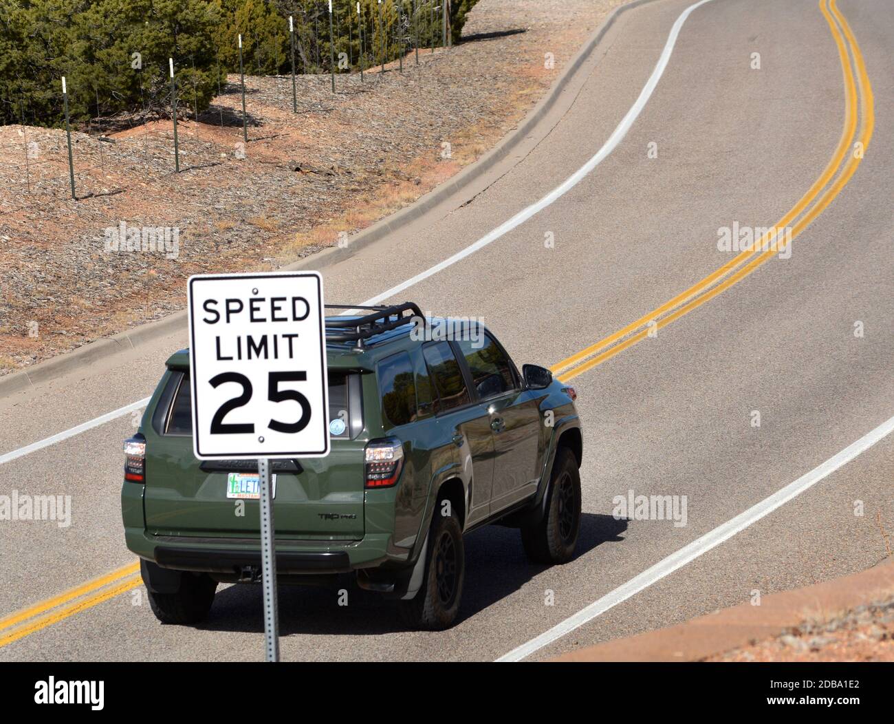 A motorist drives along a road in a residential zone in Santa Fe, New Mexico, with a 25 miles per hour speed limit. Stock Photo