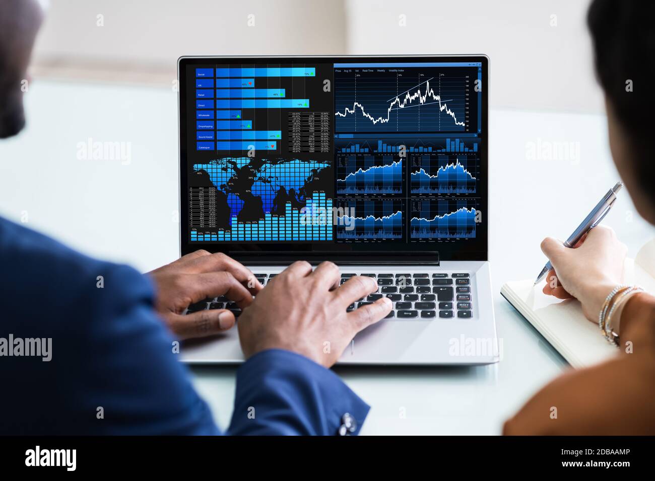 Two Businesspeople Analyzing Financial Graph On Laptop Stock Photo