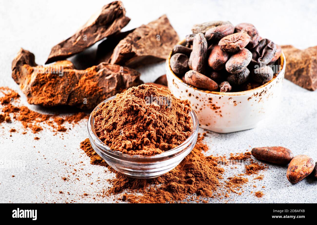 Organic cocoa powder, cocoa beans, grated cocoa lump on gray background