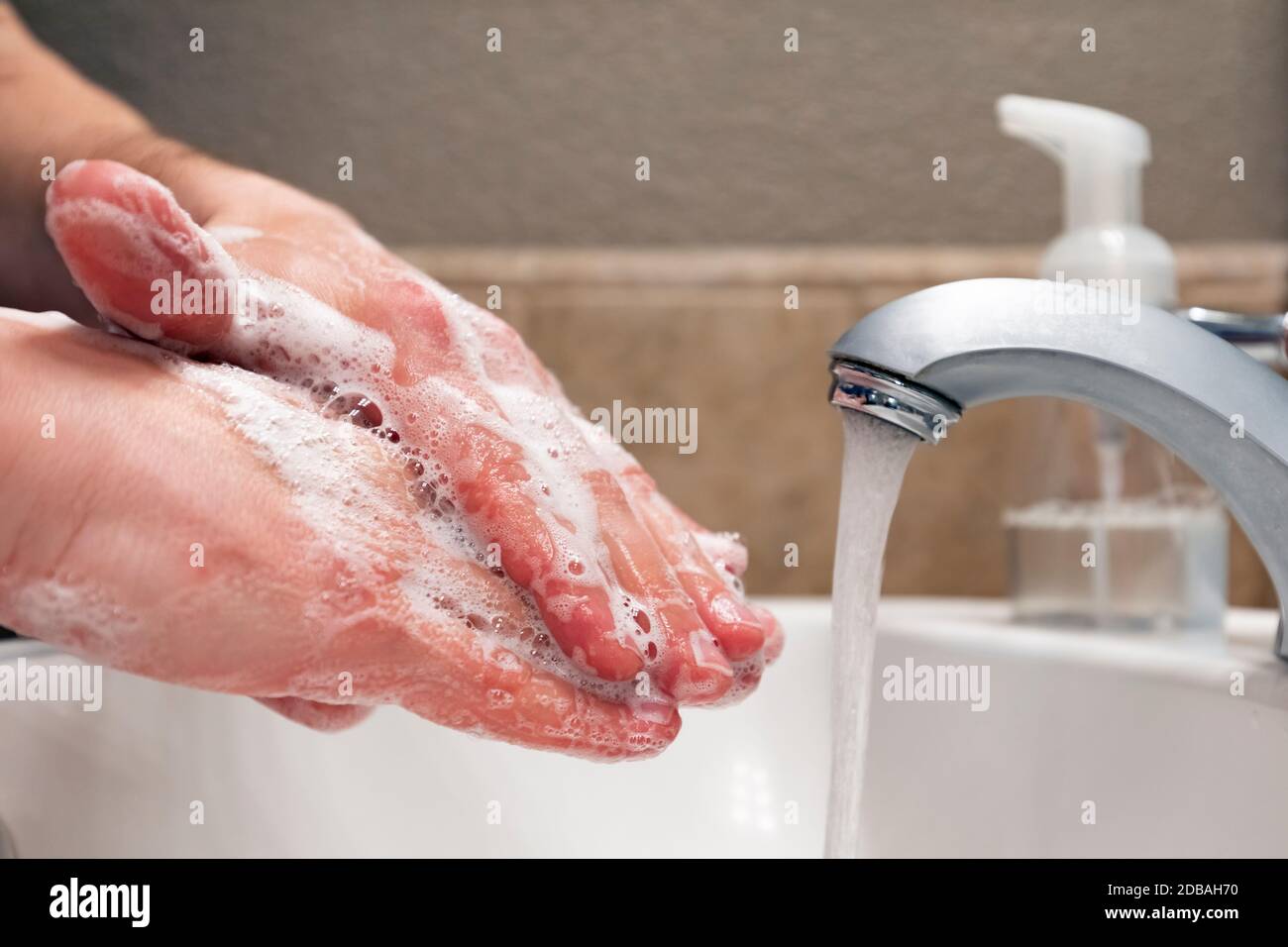 Washing hands with soap and water in bathroom sink, protection against covid-19 coronavirus flu viruses, hygiene to stay healthy Stock Photo