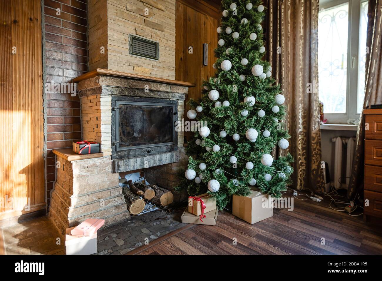 Photo of interior of room with a wooden wall, Christmas tree, fireplace ...