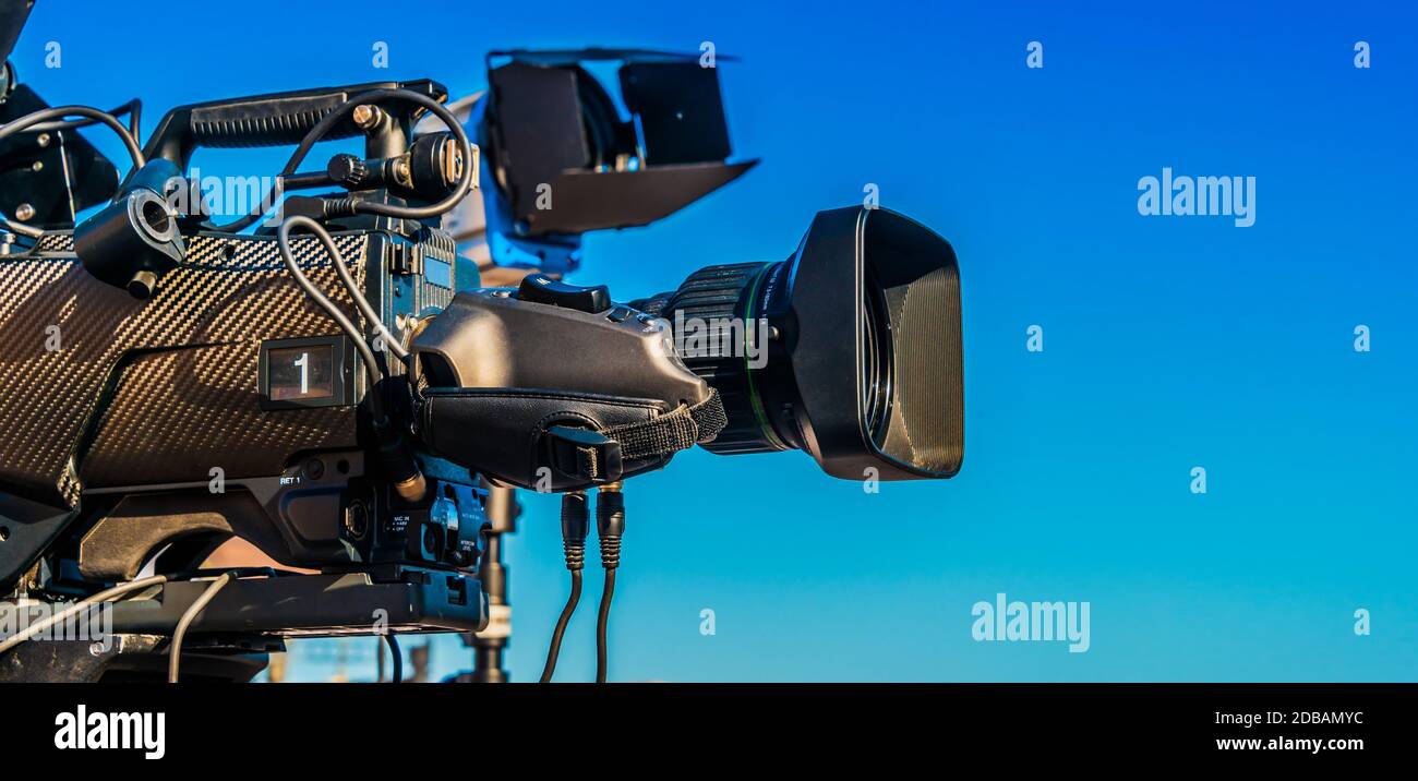 Professional tv camera on tripod recording social event on the street Stock Photo