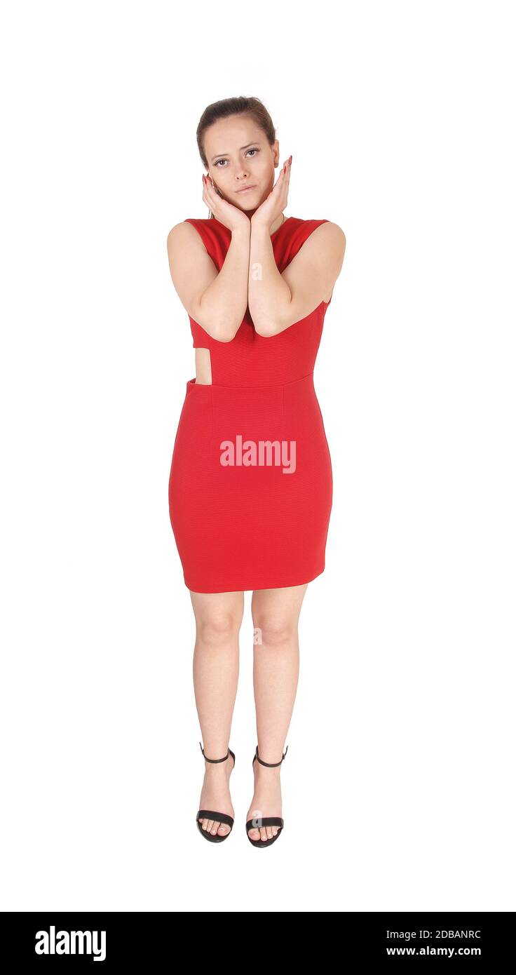 A lovely young woman standing in a red dress with both hands on her ...