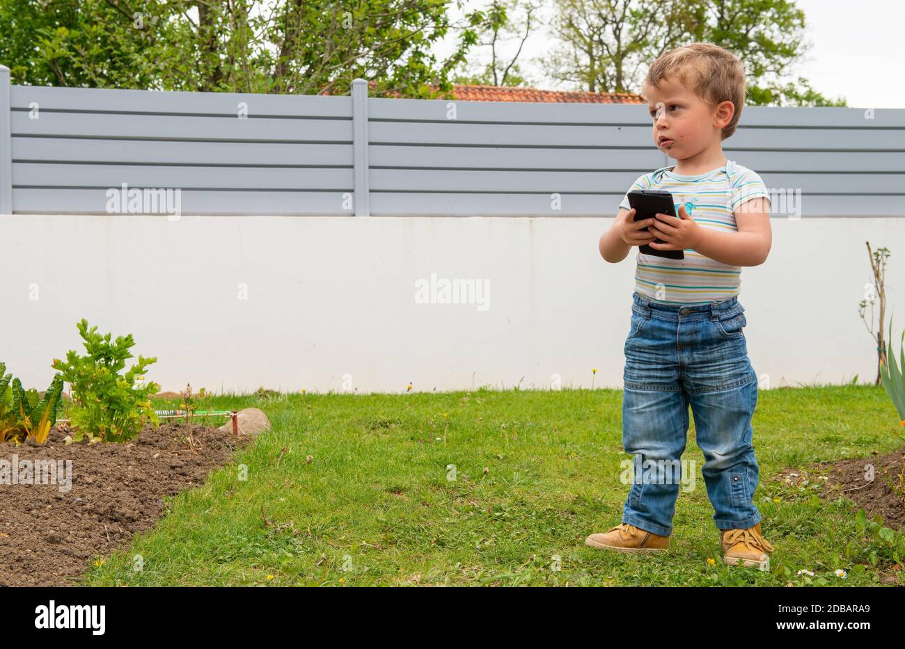 a kid use cellphone in the park Stock Photo