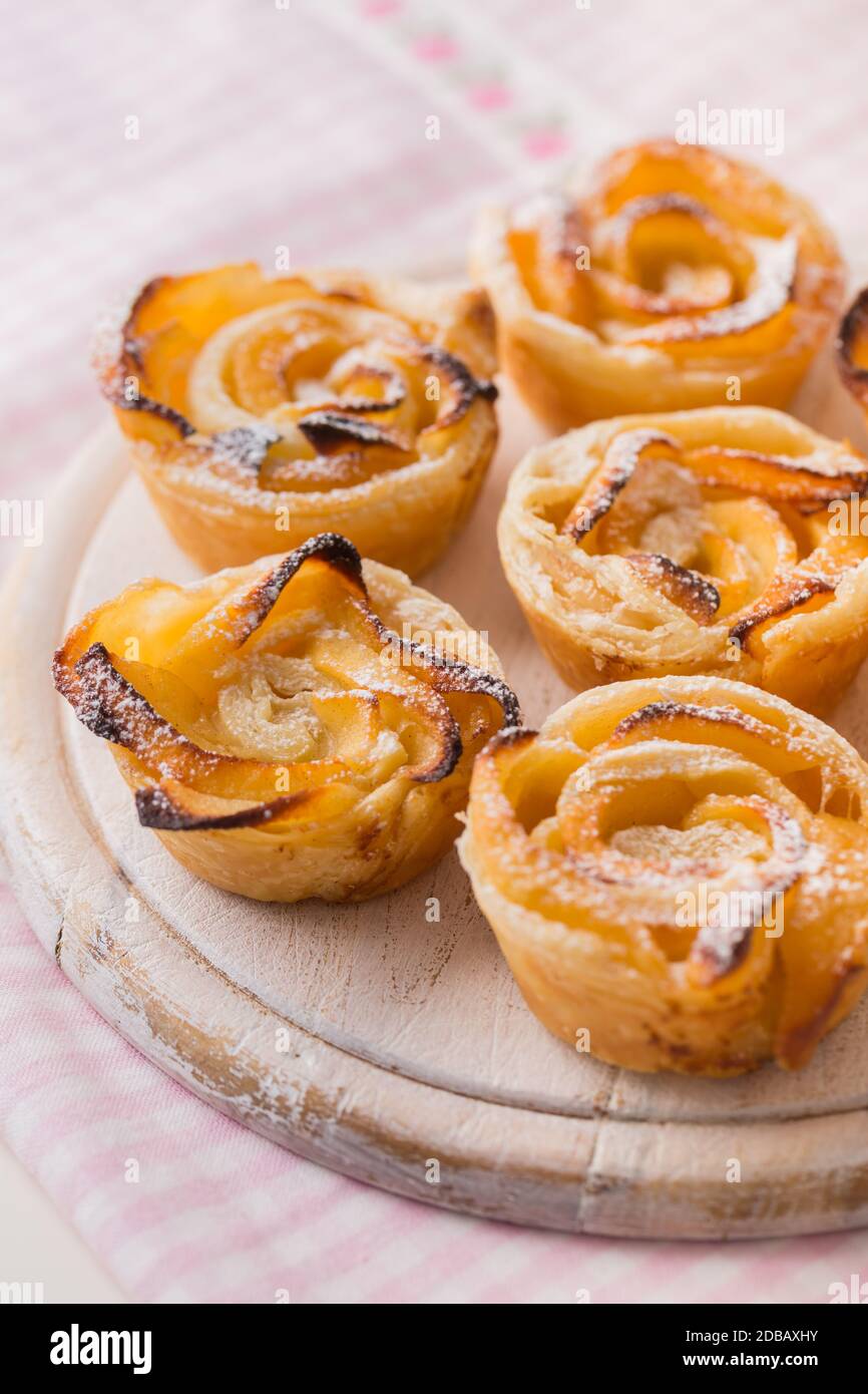 Delicious apple puff pastry in rose shape on wooden board Stock Photo