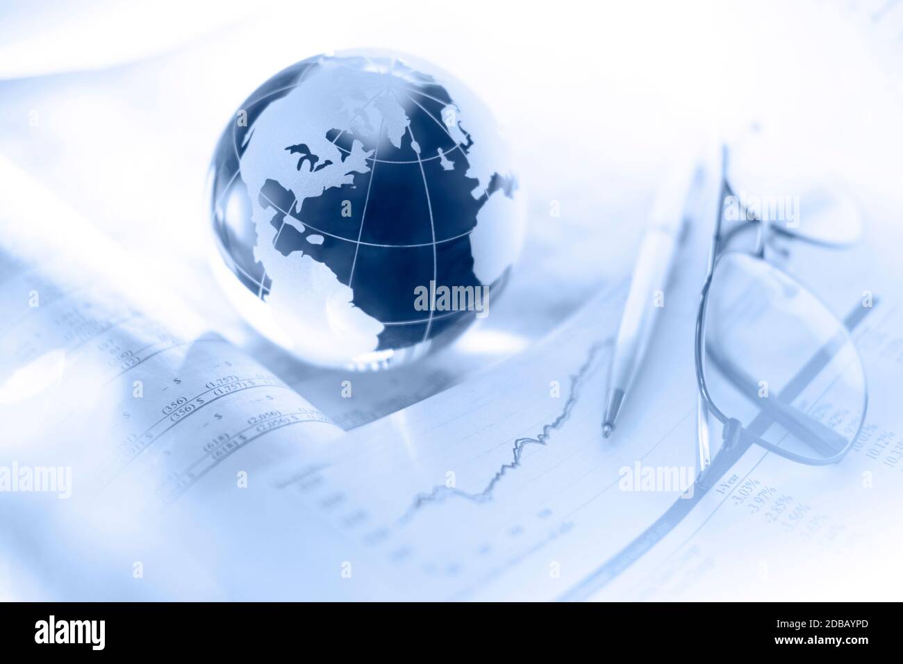 Glass globe with pen and glasses on financial charts Stock Photo