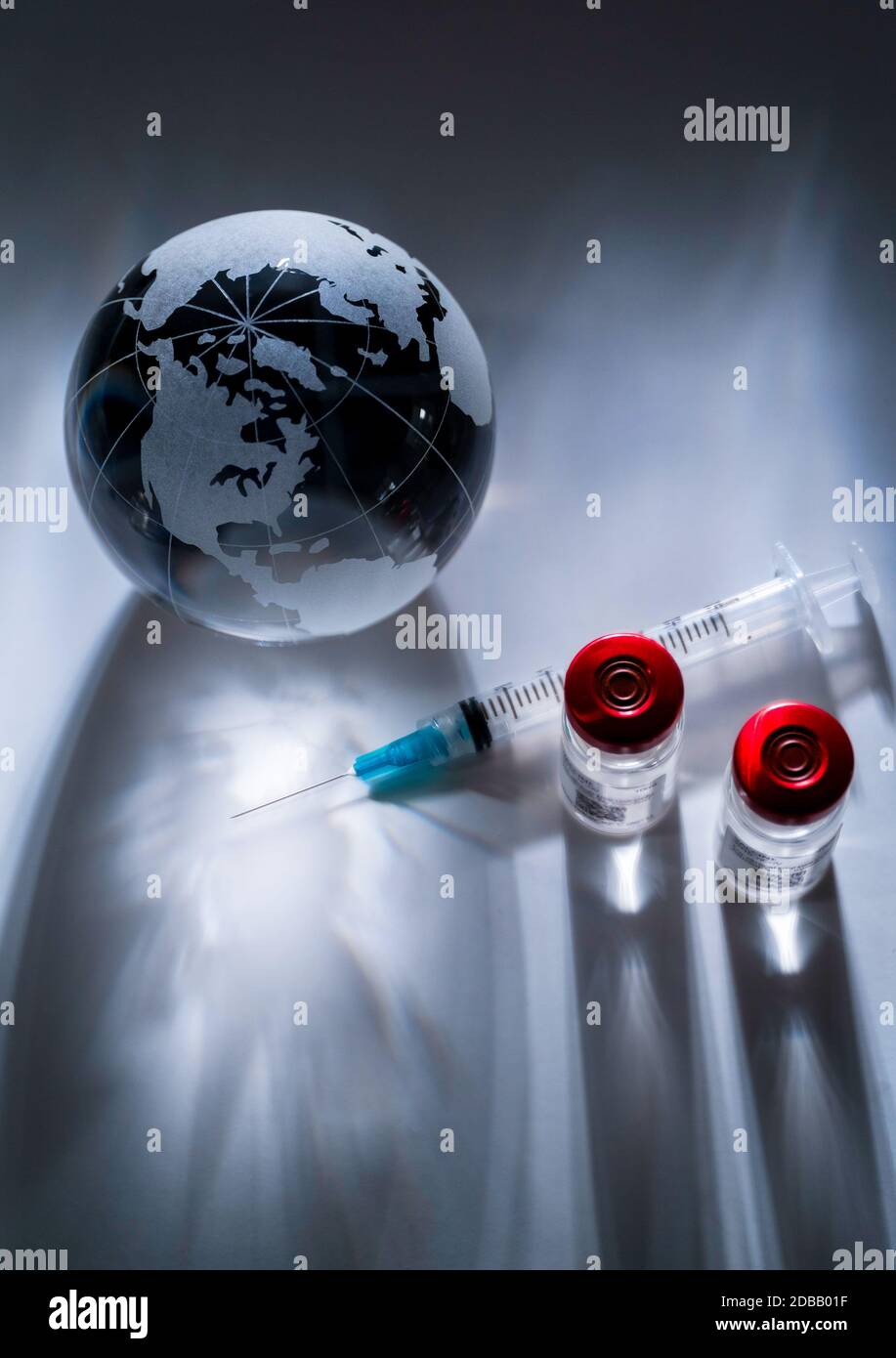 Glass globe and syringe with vaccine on gray background Stock Photo