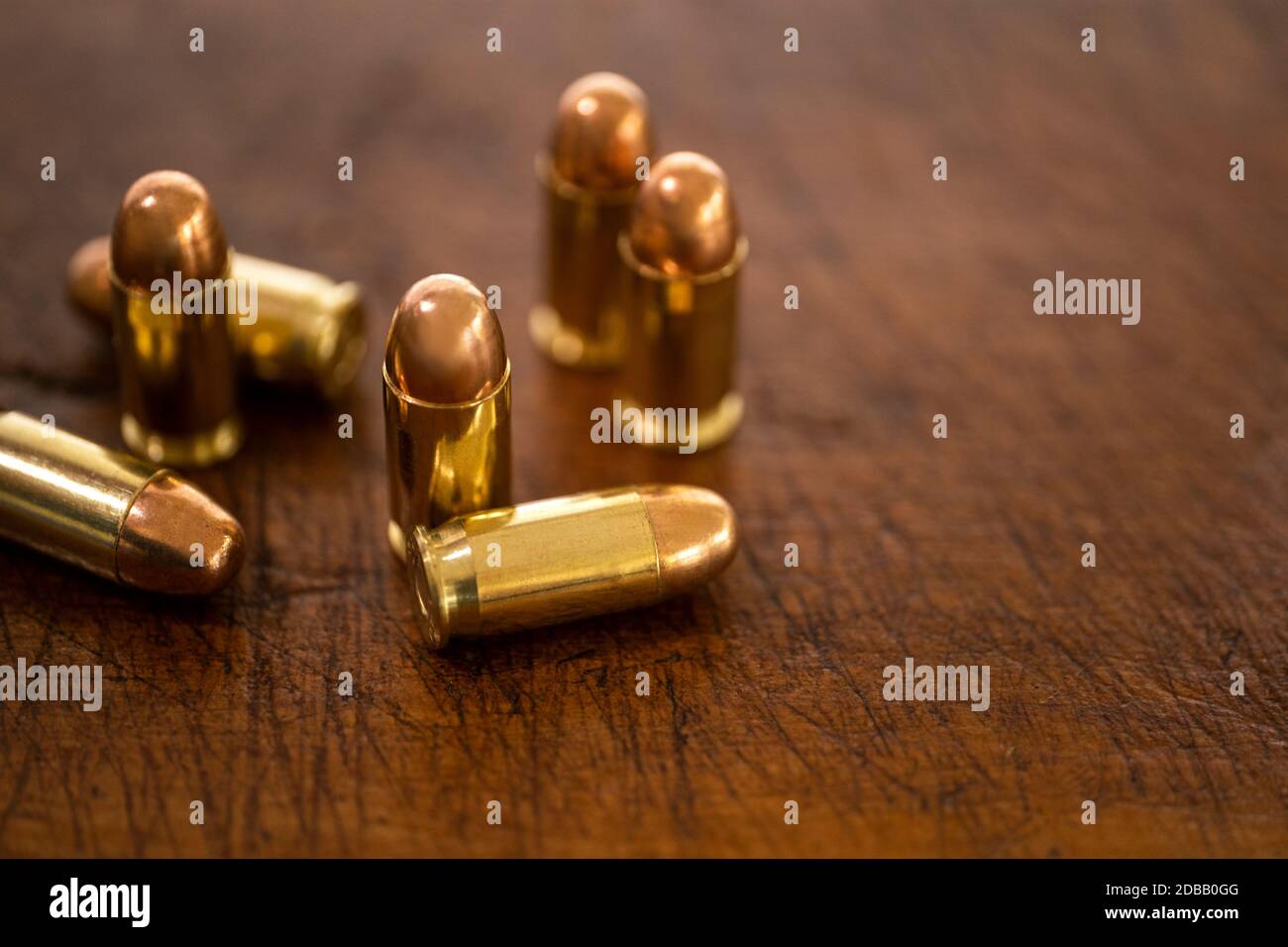 Gold bullets on wooden surface Stock Photo