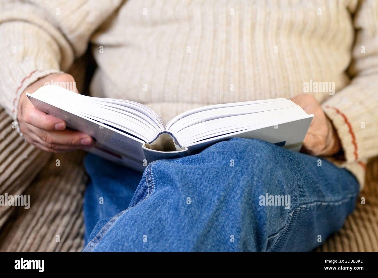 Close up view of Elderly man reading a book, while quarantine at home . Stock Photo