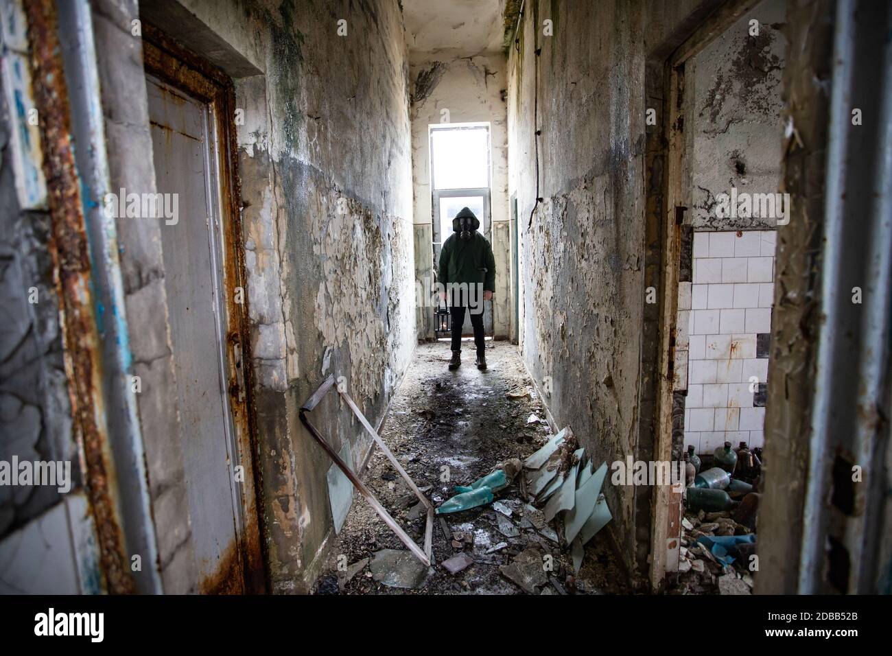 Post apocalyptic survivor in gas mask in a ruined building. Environmental disaster, armageddon concept. Stock Photo