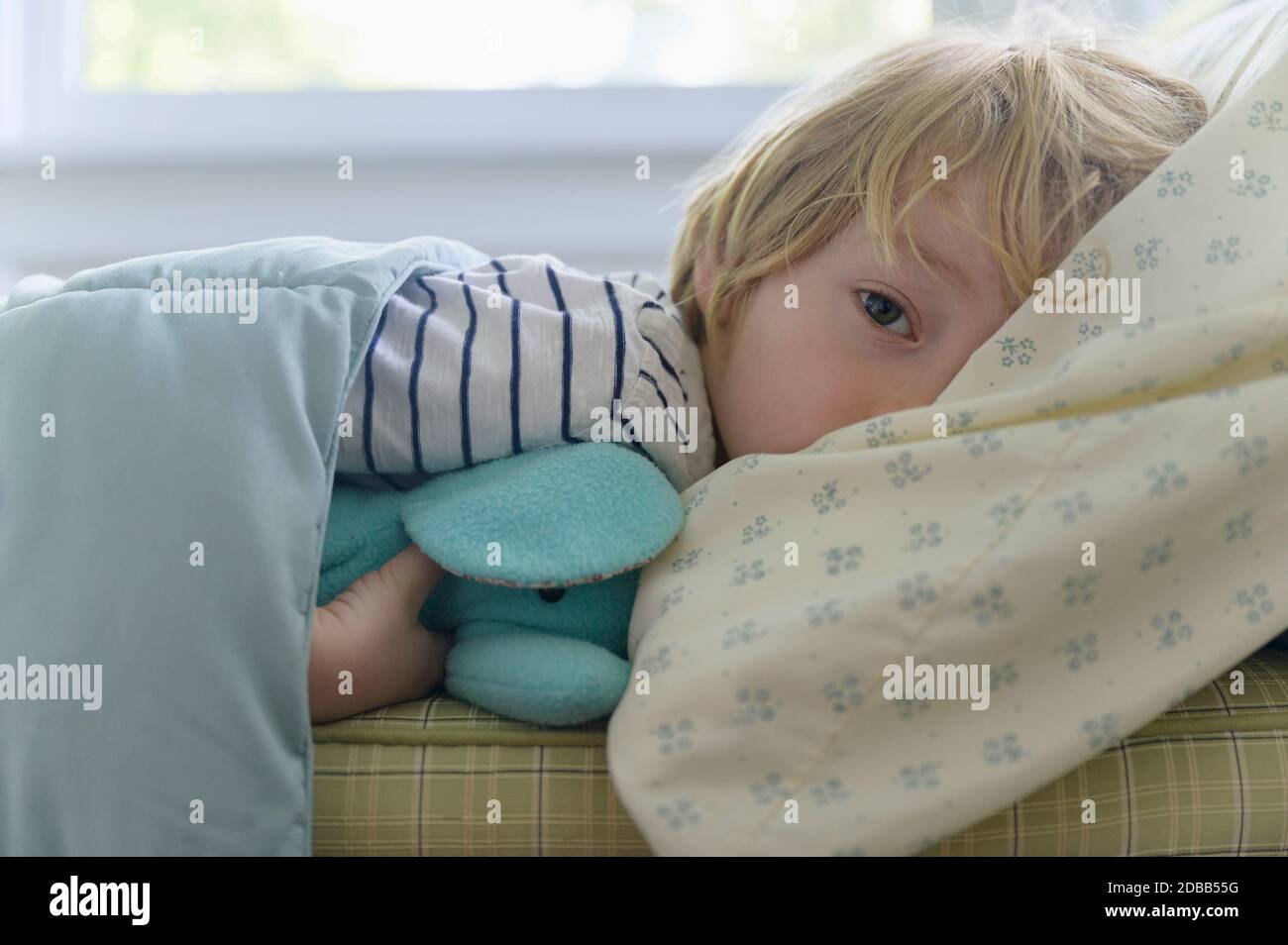Boy (4-5) lying in bed Stock Photo
