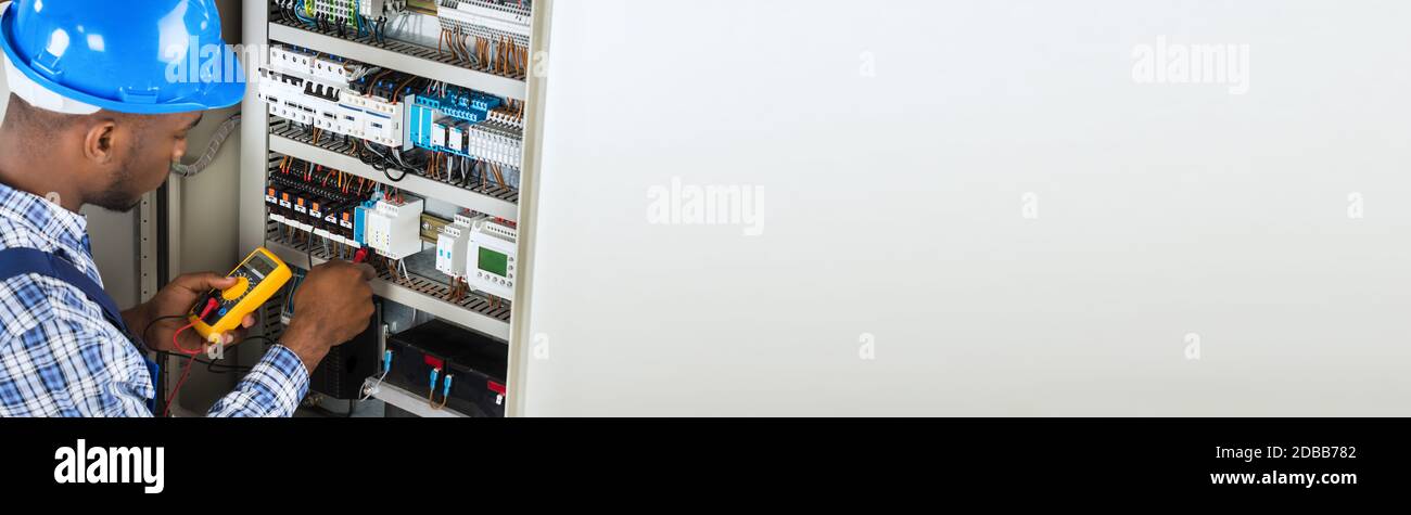 African Electrician Checking And Testing Fuse Box Stock Photo
