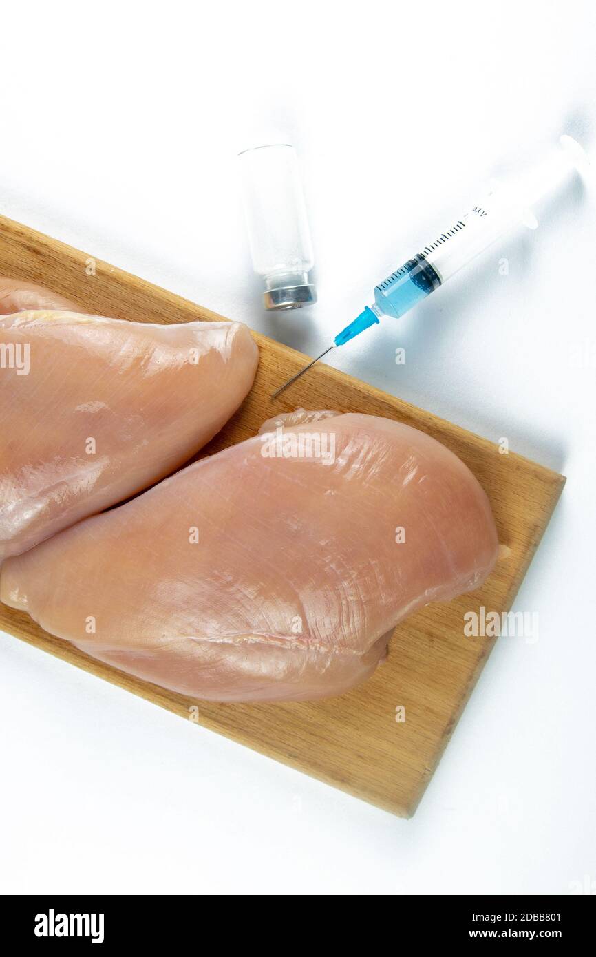 Syringe with liquid being injected to a piece of meat. Conceptual illustration for Hormones and antibiotics in food production. GMO concept. Isolated Stock Photo