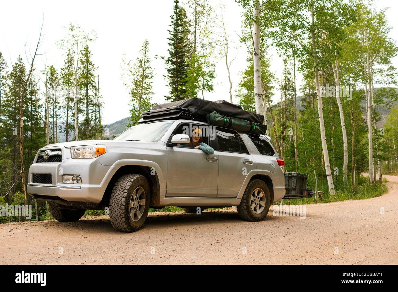 USA, Utah, Uinta National Park, Woman sitting in off road car with tent on roof Stock Photo