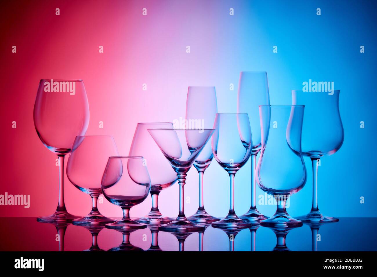 Set of glasses for different alcoholic drinks and cocktails on light