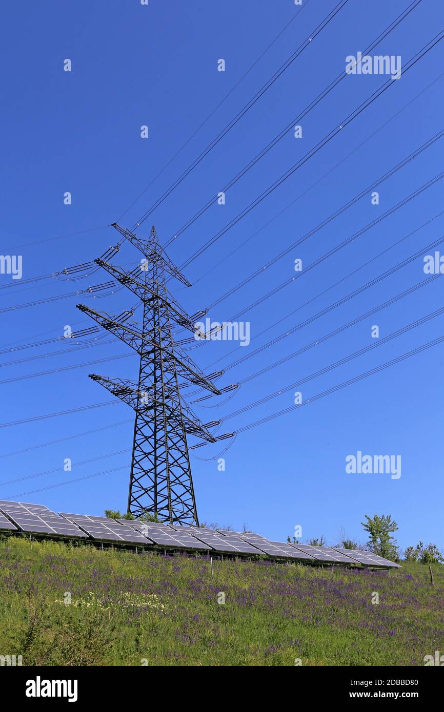 Photovoltaic system under overhead line mast Stock Photo