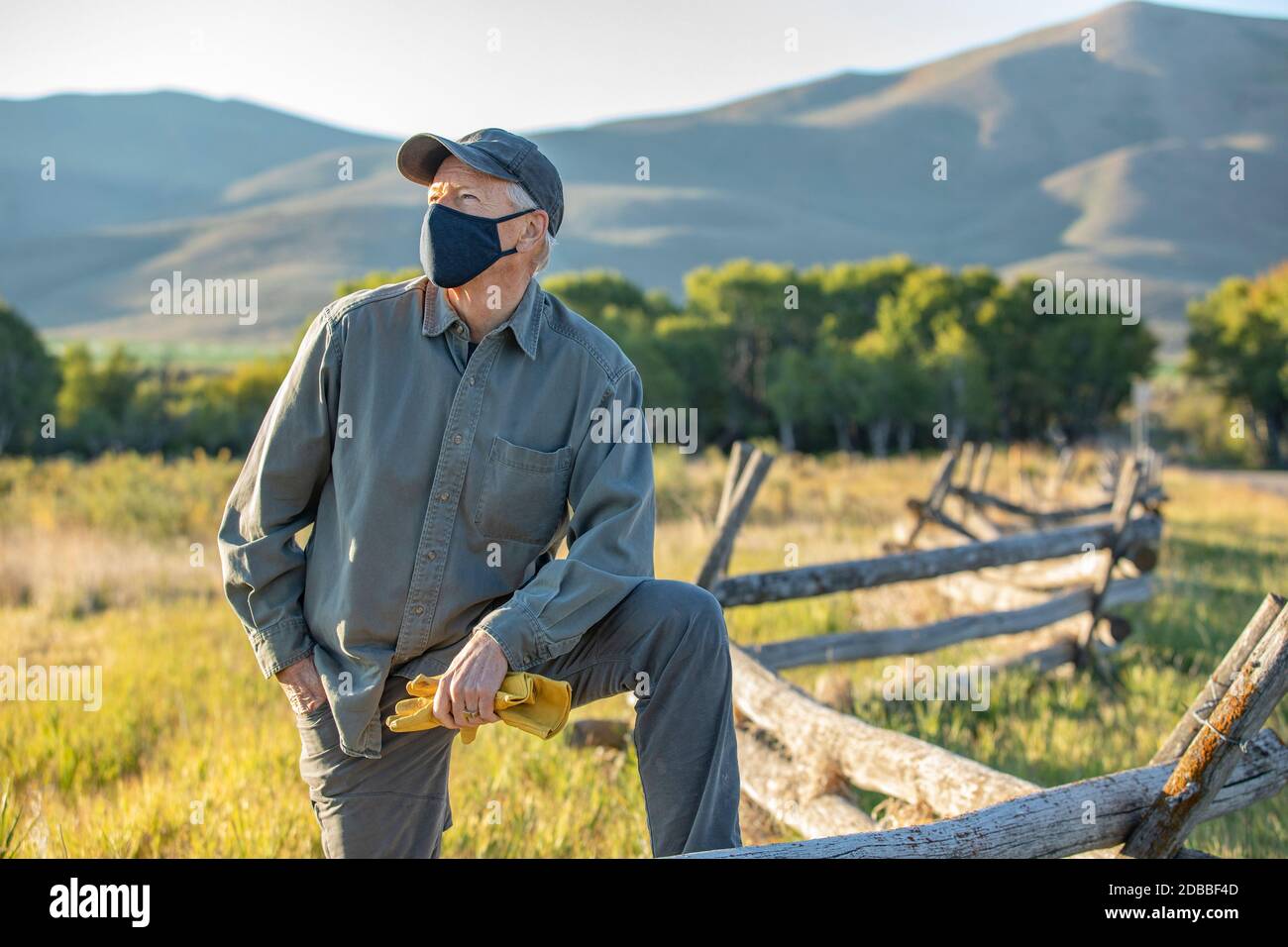 USA, Idaho, Bellevue, Farmer in face mask leaning against fence on field Stock Photo