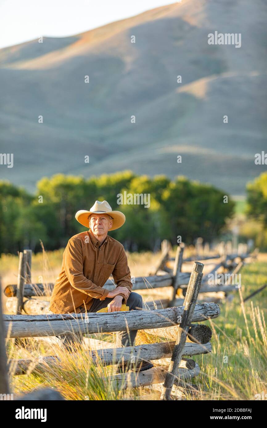 USA, Idaho, Bellevue, Rancher leaning against fence on field Stock Photo